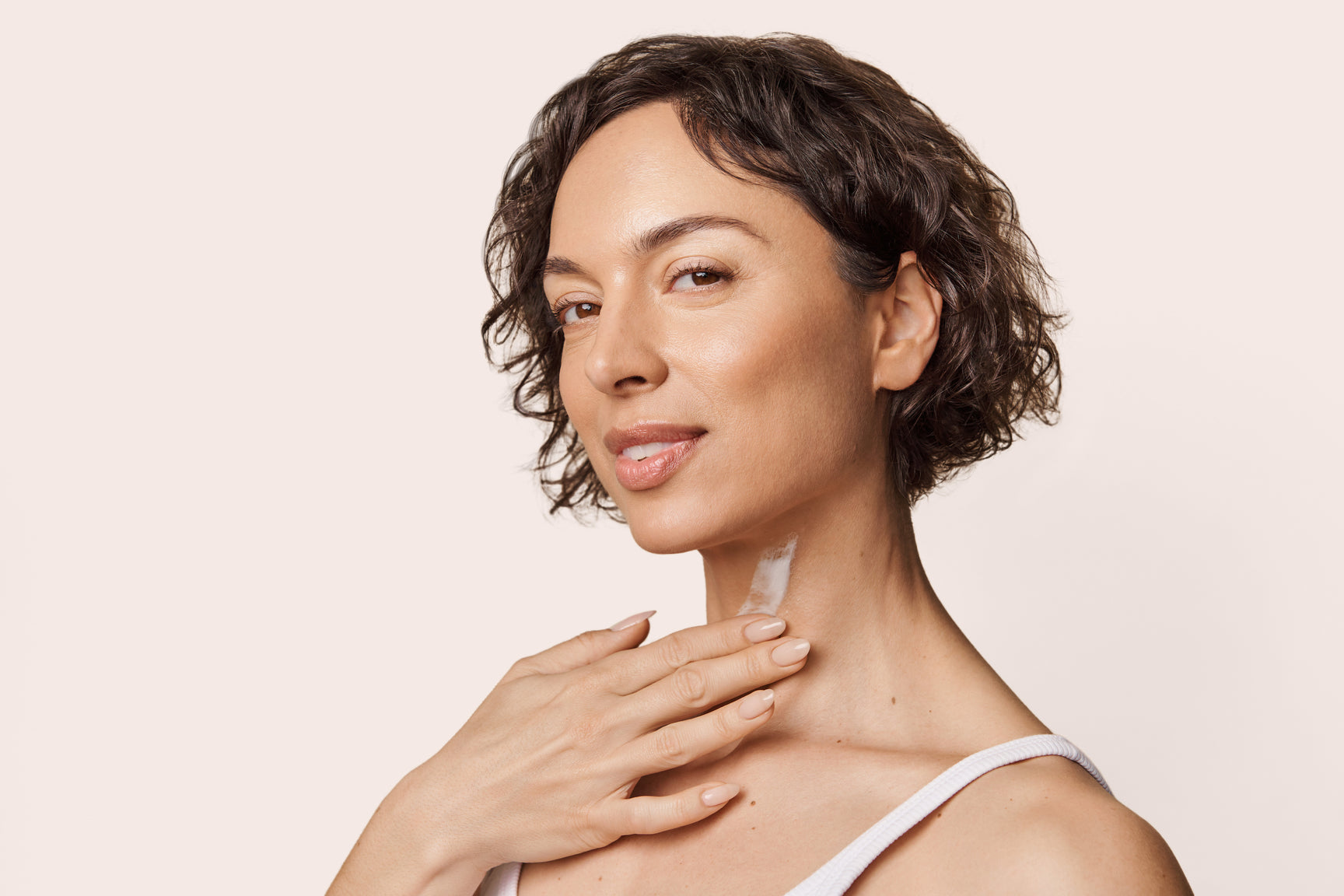 An image of a woman applying Solwave serum to her Décolleté