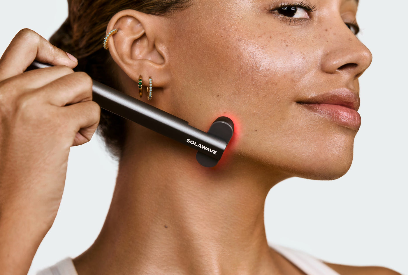 An image of a woman using red light therapy on her chin line