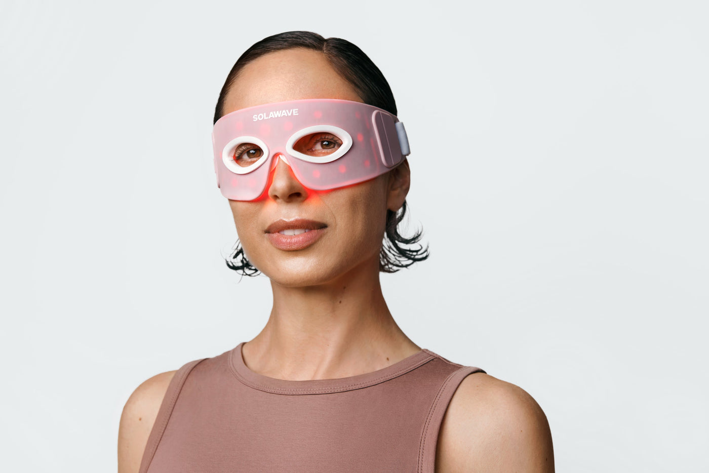 An image of a woman wearing a red light therapy eye mask 
