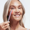 An image of a woman using the Solawave red light therapy wand on her face