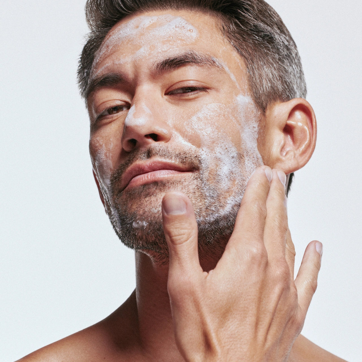 An image of a man using the Solawave facial cleanser