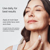 A woman applies LightBoost Face & Neck Rich Cream to her face, smiling slightly. The text reads: For best results, use daily. Apply evenly over face, neck, and chest. Use light therapy after applying Solawaves LightBoost topicals and before sunscreen or makeup.