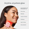 A person smiles using the SolaWave 2-in-1 Face & Body Mini Starter Kit on their neck. Text highlights its benefits: reducing fine lines, wrinkles, uneven texture, puffiness, dark circles, and discoloration. The header reads Anytime, anywhere glow with Red Light Therapy.