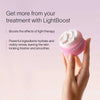 A hand holds a pink jar from the Neck & Chest LED Mask w/ LightBoost Cream Kit by Solawave against a soft pink background. Text reads: Enhance your routine with LightBoost. Boost red light therapy effects; powerful ingredients hydrate and renew, leaving skin looking fresher and smoother.