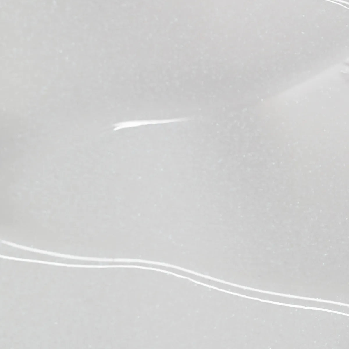 A close-up of a smooth, glossy surface marked by gentle curves and subtle highlights evokes the minimalist essence of the Solawave LightBoost Face & Neck Serum. The soft white texture mirrors a luxurious skin renewal serum.