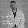 A man in a medical coat sits against a wooden paneled background. Text reads: Expert Review. Solawave offers an easy and effective way for patients to use red light therapy at home with the 4-in-1 Skincare Wand & 3-Month Serum Kit. - Daniel Gould, MD, PhD.