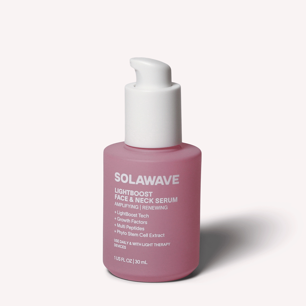 A 1 fl oz (30 ml) pink bottle of Solawaves LightBoost Face & Neck Serum features a white pump and Amplifying | Renewing label. It contains LightBoost Tech, growth factors, and Multi Peptides for elevated skincare.