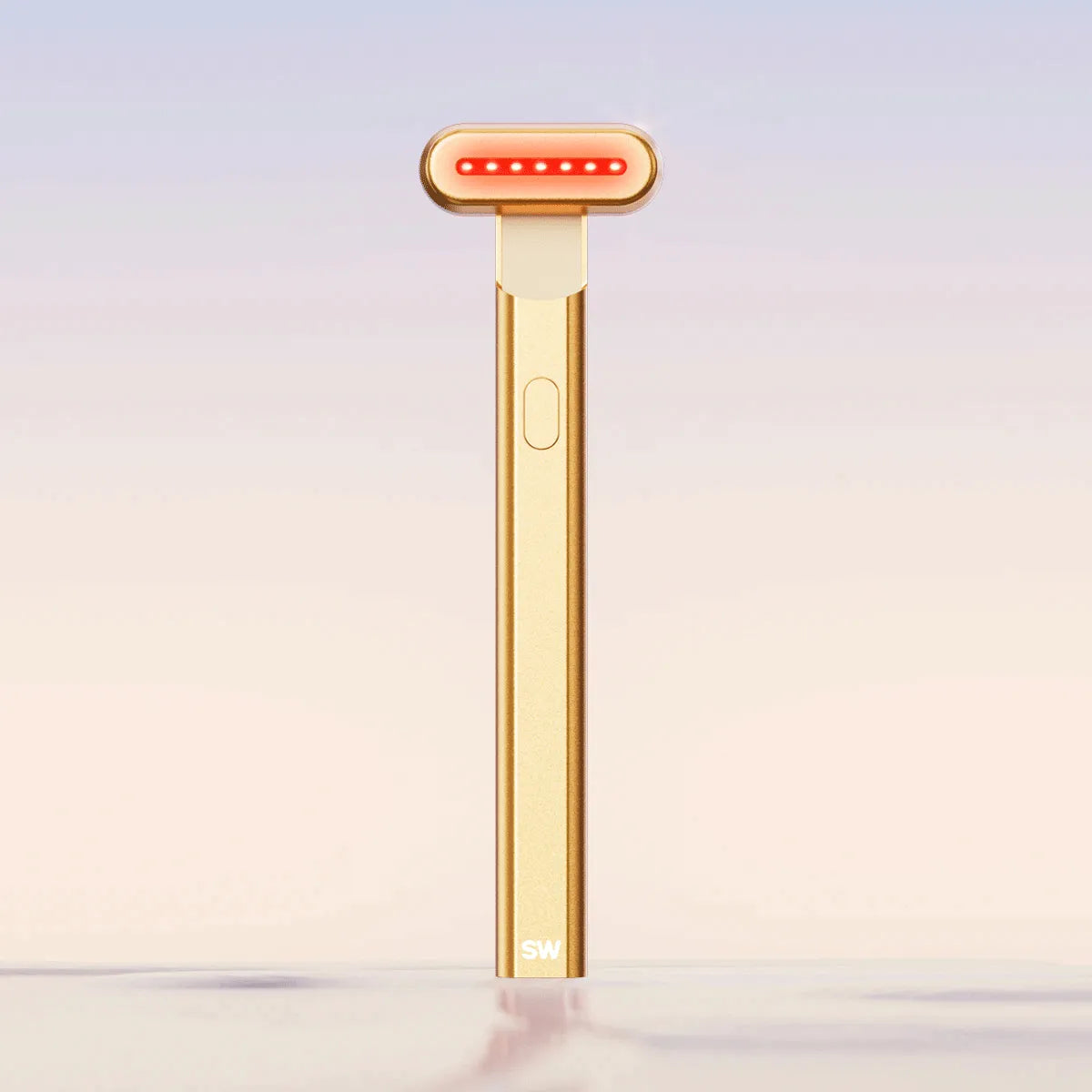 The SolaWave 4-in-1 Radiant Renewal Skincare Wand in gold has a rounded top and red LED lights for effective therapy. It complements soft pastel backgrounds, offering a minimalist, modern solution for addressing wrinkles. || Gold